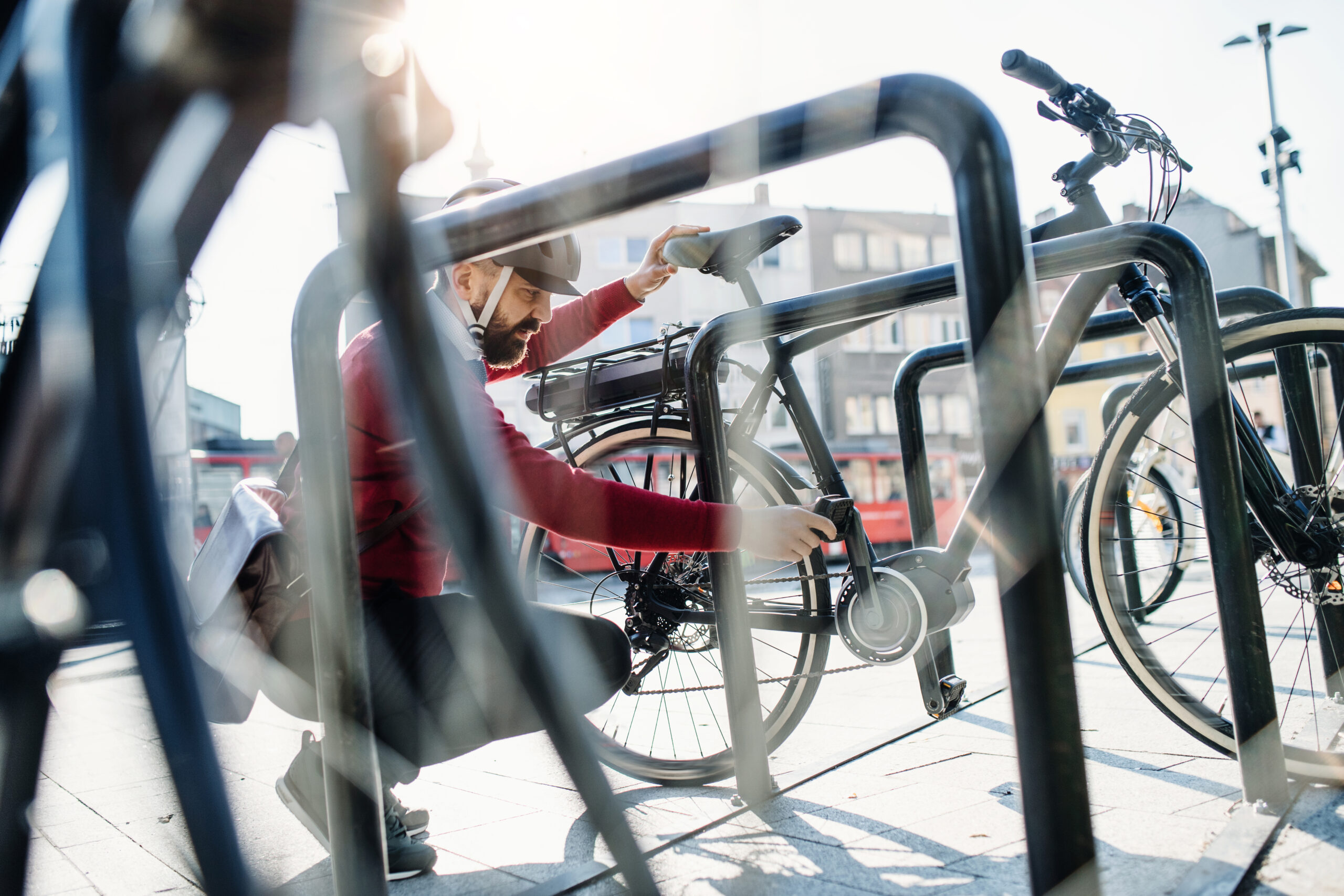Hipster businessman commuter parking electric bicycle in city when going to work.